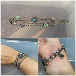silver and blue layered chain bracelet with floral charms. 6-7” adjustable